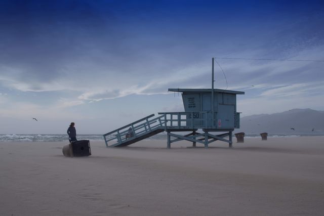 Person Standing Near Cabin Near Beach Shore - Download Free Stock Photos Pikwizard.com