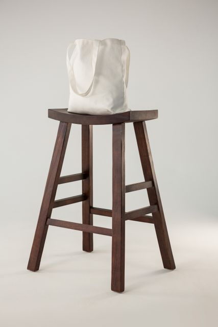 White bag on wooden stool - Download Free Stock Photos Pikwizard.com