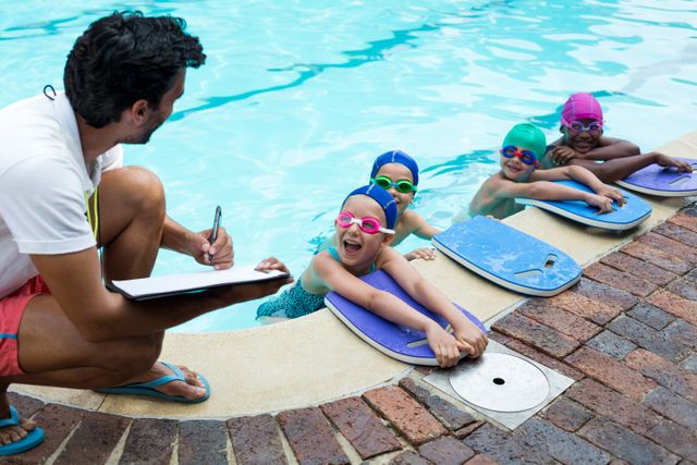 Instructor writing on clipboard with swimmers at poolside - Download Free Stock Photos Pikwizard.com