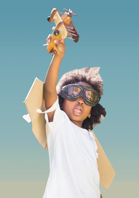 Superhero kid in flying goggles playing with toy aeroplane - Download Free Stock Photos Pikwizard.com