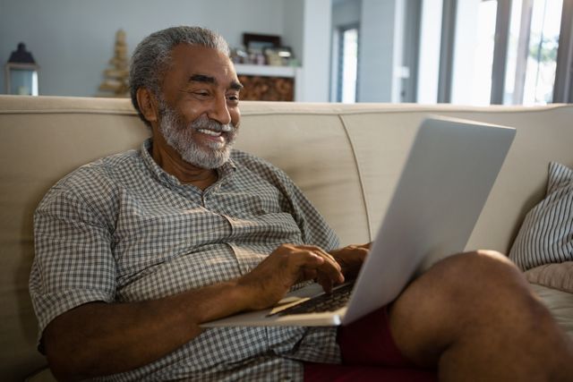 Senior man using laptop in the living room - Download Free Stock Photos Pikwizard.com