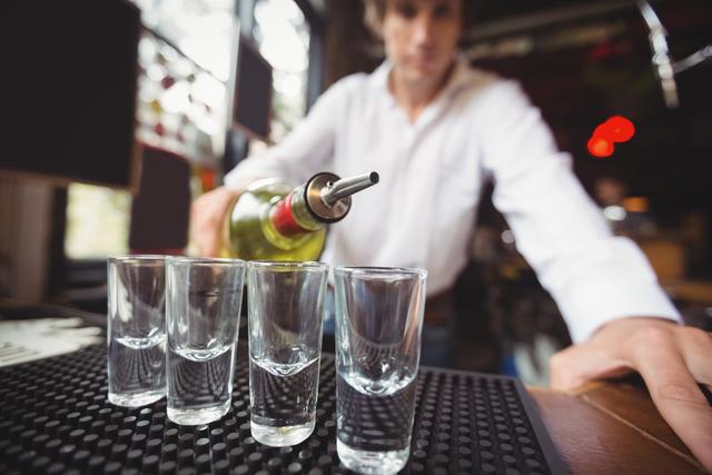Close-up of bartender pouring tequila in shot glasses - Download Free Stock Photos Pikwizard.com
