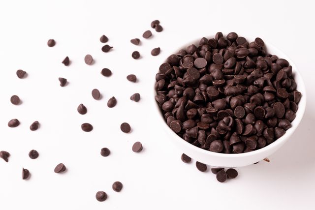 High angle view of chocolate chips in bowl on white background, copy space - Download Free Stock Photos Pikwizard.com