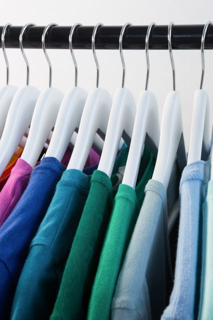 Colorful t-shirts arranged in a row on cloth rack - Download Free Stock Photos Pikwizard.com