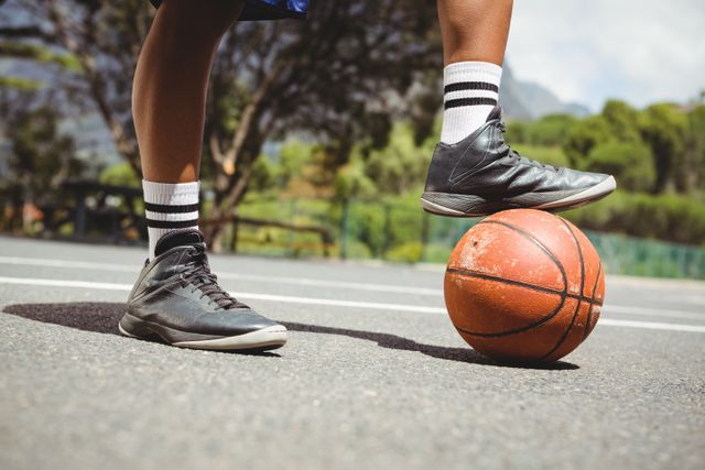 Close up of man standing with one leg on basketball - Download Free Stock Photos Pikwizard.com
