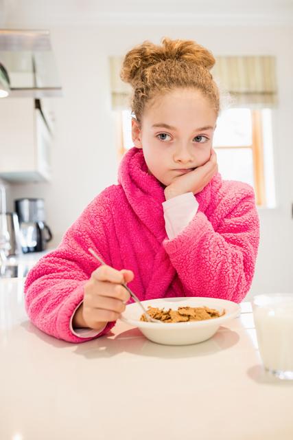 Sad girl having breakfast in kitchen - Download Free Stock Photos Pikwizard.com