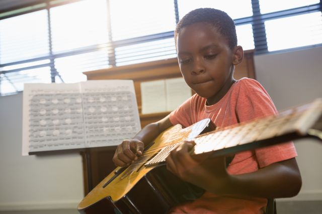 Boy playing guitar in class at music school