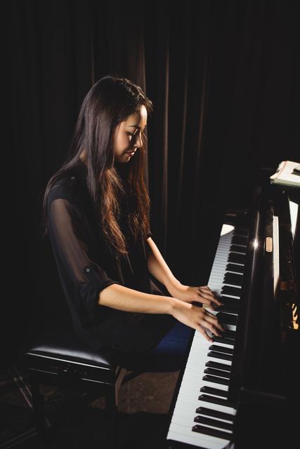 Woman playing a piano in music studio - Download Free Stock Photos Pikwizard.com