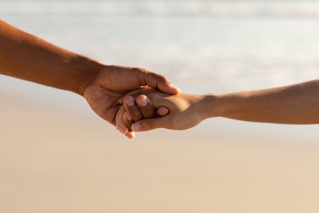 Couple holding hands of each other on the beach - Download Free Stock Photos Pikwizard.com