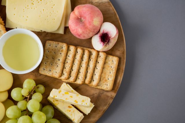 Variety of cheese with grapes, peach and crackers - Download Free Stock Photos Pikwizard.com
