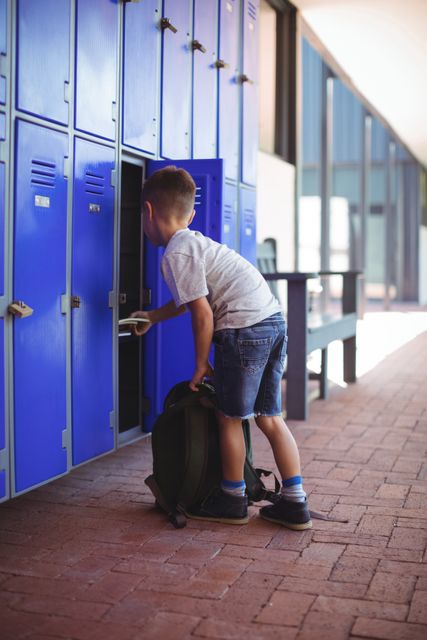Full elngth of boy taking books from locker - Download Free Stock Photos Pikwizard.com