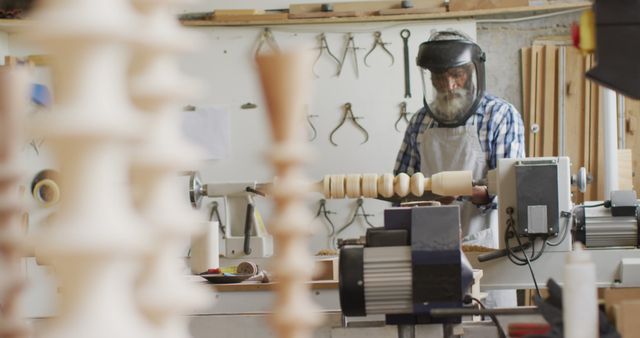 African american male carpenter wearing protective helmet turning wood on a lathe at carpentry shop. Carpentry, craftsmanship and handwork concept