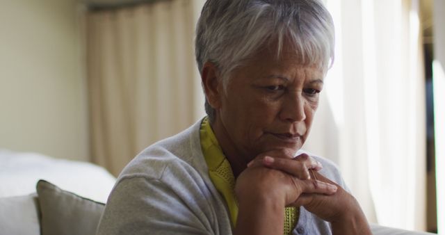 Senior mixed race woman sitting in bedroom thinking - Download Free Stock Photos Pikwizard.com