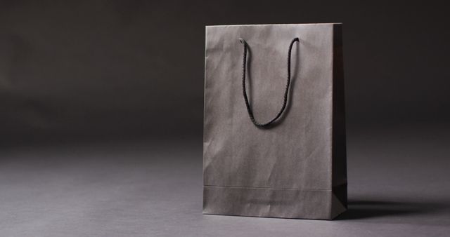 Black gift bag with black handles on dark grey background with copy space - Download Free Stock Photos Pikwizard.com