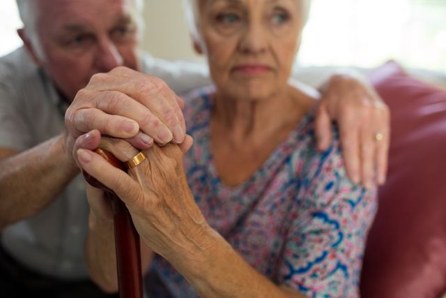 Senior man holding hands of old woman with walking stick in living room - Download Free Stock Photos Pikwizard.com
