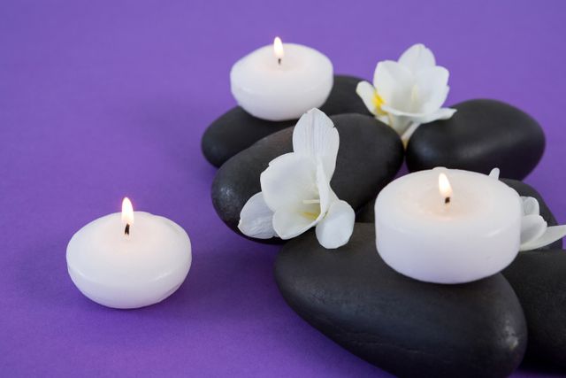 White flowers, candles on zen stone - Download Free Stock Photos Pikwizard.com