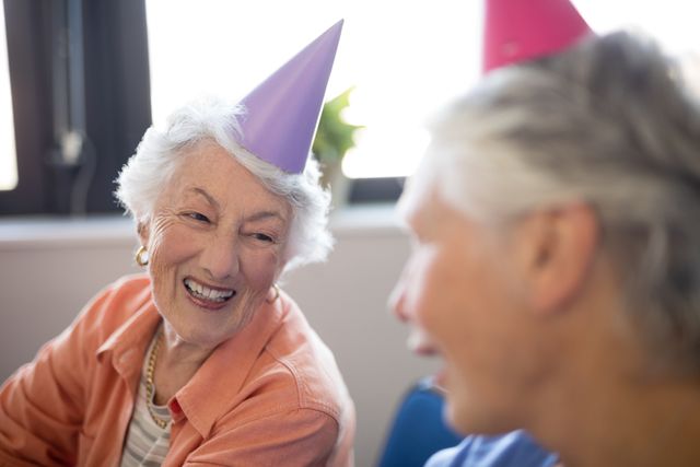 Smiling senior women wearing party hats - Download Free Stock Photos Pikwizard.com