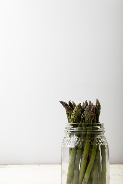 Close-up of asparagus in jar against white background, copy space - Download Free Stock Photos Pikwizard.com