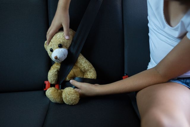 Teenage girl sitting with teddy bear in the back seat of car - Download Free Stock Photos Pikwizard.com