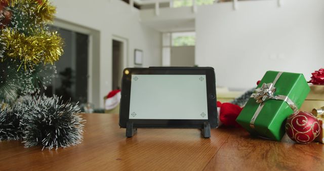 Close up of tablet with copy space on screen, sitting on table in living room at christmas. christmas, winter, tradition and celebration at home.
