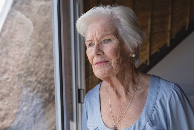 Senior woman looking through window - Download Free Stock Photos Pikwizard.com