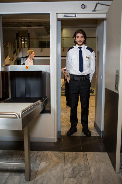 Security guard standing under the scanning door - Download Free Stock Photos Pikwizard.com
