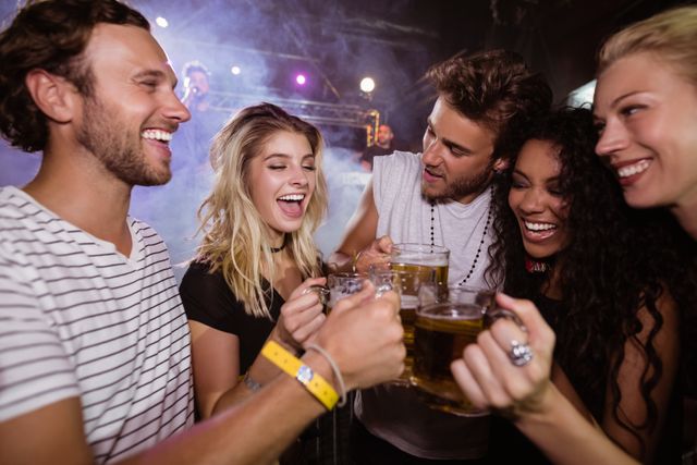 Happy friends toasting beer mugs at nightclub - Download Free Stock Photos Pikwizard.com