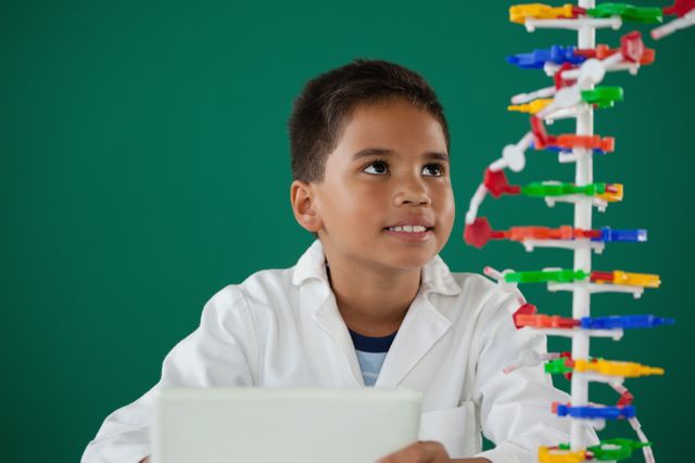 Smiling schoolboy experimenting molecule model in laboratory - Download Free Stock Photos Pikwizard.com