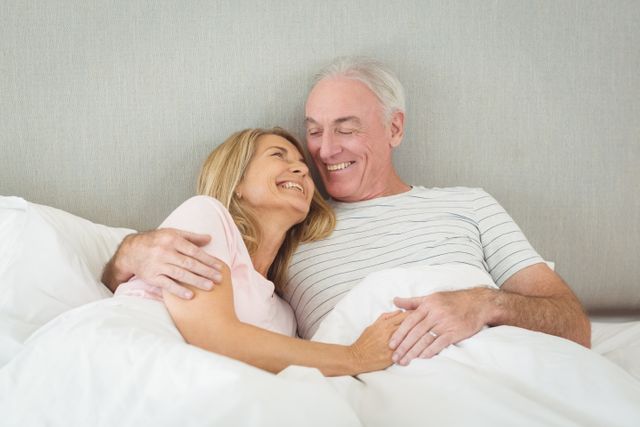 Senior couple embracing on bed- Download Free Stock Photos Pikwizard.com