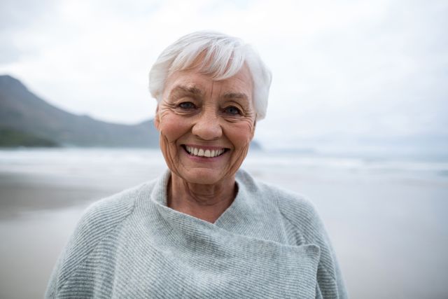 Portrait of smiling senior woman standing on the beach