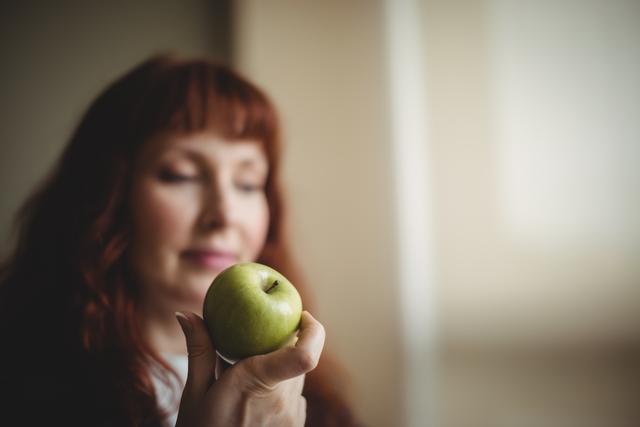 Businesswoman holding an apple in office