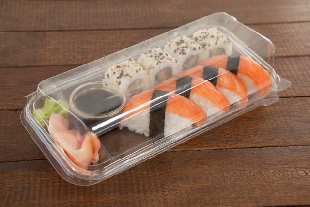 Nigiri and uramaki sushi kept with soy sauce in a plastic box - Download Free Stock Photos Pikwizard.com