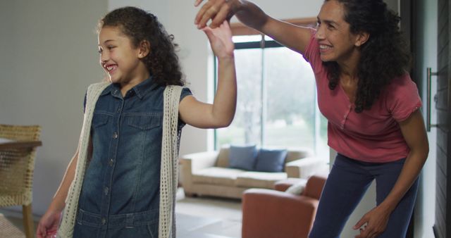 Happy mixed race mother and daughter dancing in living room - Download Free Stock Photos Pikwizard.com
