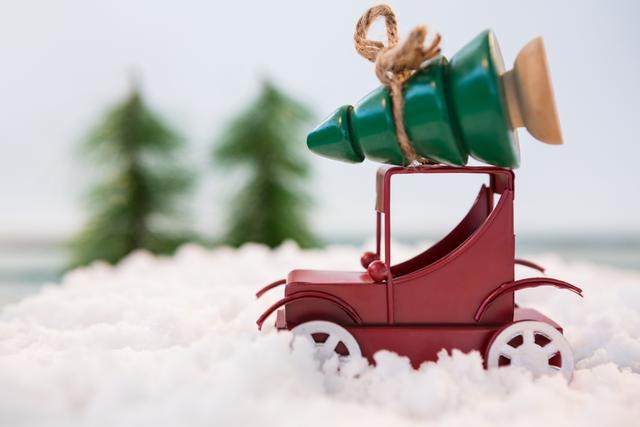 Toy car carrying christmas tree on fake snow - Download Free Stock Photos Pikwizard.com