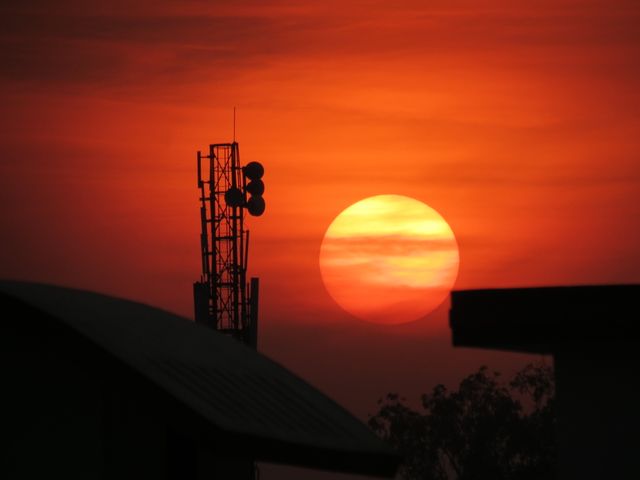 the sun setting behind a cell tower - Download Free Stock Photos Pikwizard.com