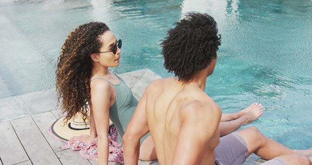 Image of happy diverse couple relaxing in the sun and talking at the poolside of holiday home - Download Free Stock Photos Pikwizard.com