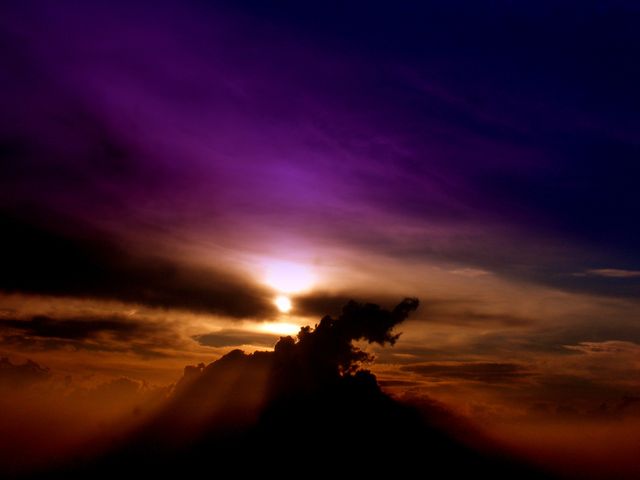 a sunset with a mountain in the background - Download Free Stock Photos Pikwizard.com