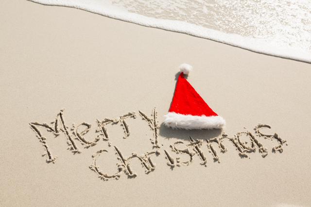 Merry Christmas written on sand with santa hat - Download Free Stock Photos Pikwizard.com