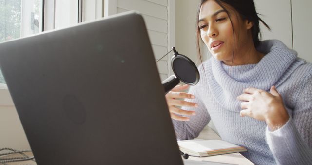 Image of biracial woman taking part in online interview on laptop at home. Home office, working from home with technology concept.