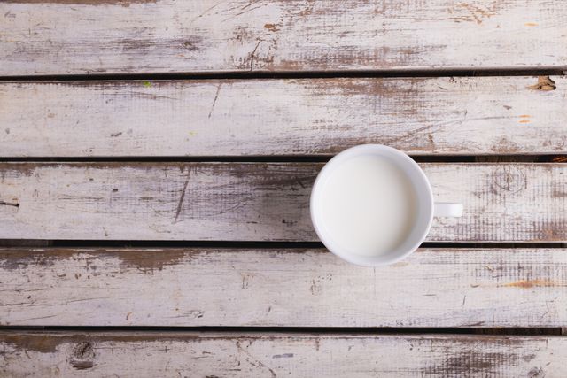 Directly above shot of milk in cup on wooden table, copy space - Download Free Stock Photos Pikwizard.com