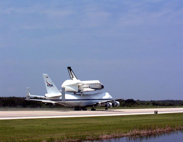 KENNEDY SPACE CENTER, FLA. -- From the Shuttle Landing Facility at Kennedy Space Center, the orbiter Columbia moves down the runway on the back of a Boeing 747 Shuttle Carrier Aircraft on a ferry flight to Palmdale, Calif. On the rear of the orbiter can be seen the tail cone, a fairing that is installed over the aft fuselage of the orbiter to decrease aerodynamic drag and buffet when the Shuttle Carrier Aircraft is transporting the orbiter cross-country. It is 36 feet long, 25 feet wide, and 22 feet high. Columbia, the oldest of four orbiters in NASA's fleet, will undergo extensive inspections and modifications in Boeing's Orbiter Assembly Facility during a nine-month orbiter maintenance down period (OMDP), the second in its history. Orbiters are periodically removed from flight operations for an OMDP. Columbia's first was in 1994. Along with more than 100 modifications on the vehicle, Columbia will be the second orbiter to be outfitted with the multifunctional electronic display system, or "glass cockpit." Columbia is expected to return to KSC in July 2000