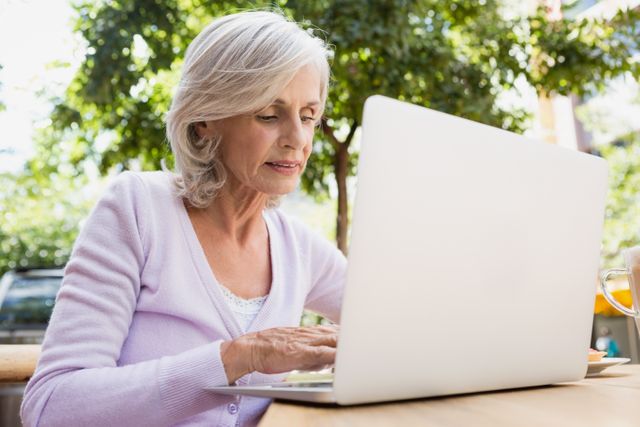 Senior woman using laptop in outdoor cafÃ© - Download Free Stock Photos Pikwizard.com