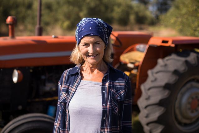 Portrait of happy woman standing against tractor in olive farm - Download Free Stock Photos Pikwizard.com