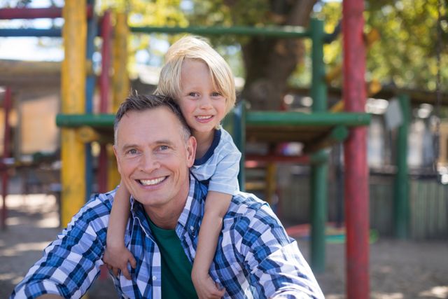 Happy son leaning on father at playground - Download Free Stock Photos Pikwizard.com