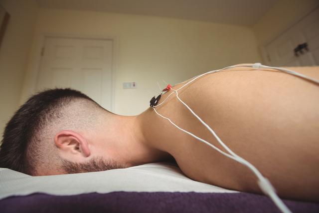 Patient getting electro dry needling on his shoulder - Download Free Stock Photos Pikwizard.com