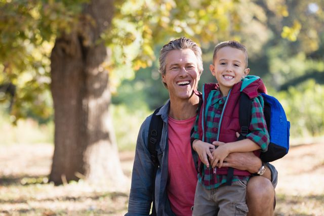 Portrait of happy father and son in forest - Download Free Stock Photos Pikwizard.com