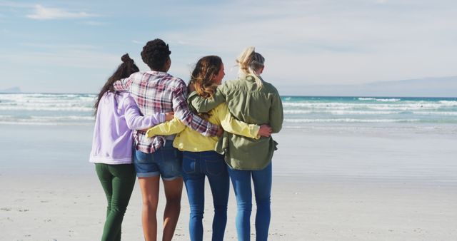 Happy group of diverse female friends having fun, walking along beach. holiday, freedom and leisure time outdoors.