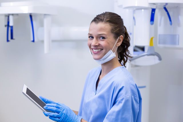 Smiling dental assistant using digital tablet - Download Free Stock Photos Pikwizard.com
