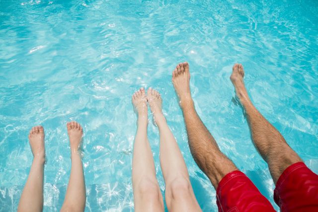Family sitting on poolside and shaking their legs in pool water - Download Free Stock Photos Pikwizard.com