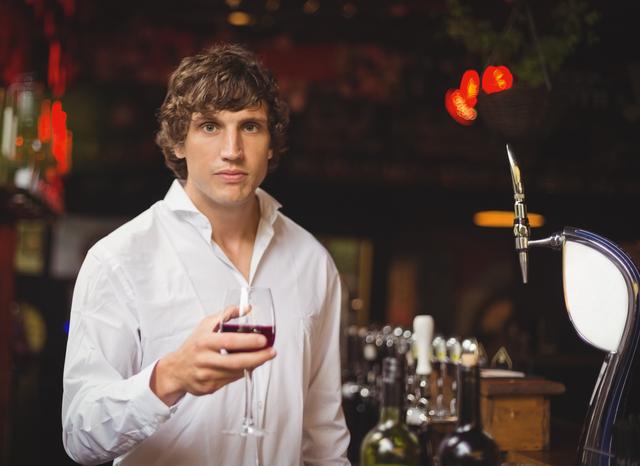 Portrait of bar tender holding glass of red wine - Download Free Stock Photos Pikwizard.com